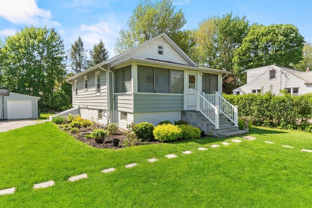 view of front facade featuring a garage, a front yard, and an outdoor structure