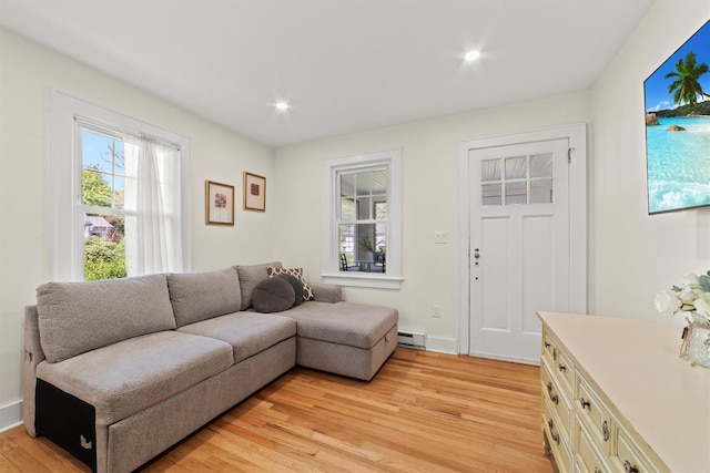 living area with light wood finished floors, a baseboard radiator, and recessed lighting