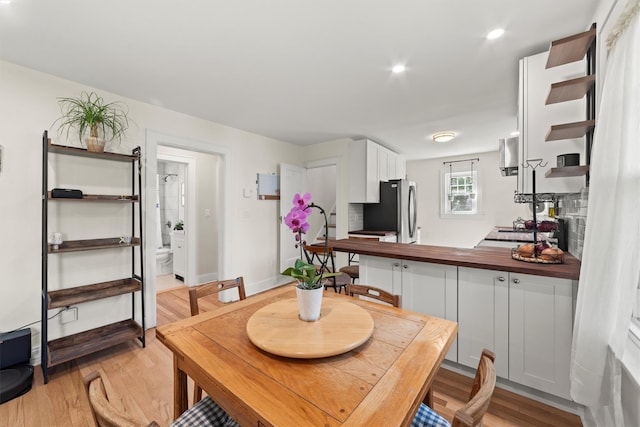 dining space with light wood-style flooring and recessed lighting
