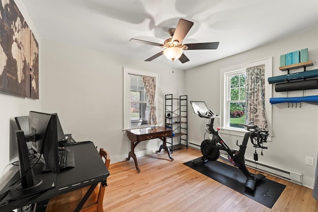 workout room featuring a ceiling fan, light wood-style floors, a baseboard radiator, and baseboards