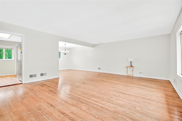 22 Chauncey St, Tuckahoe, NY 10707 - unfurnished living room featuring a chandelier, light wood-type flooring, healthy amount of natural light, and baseboards