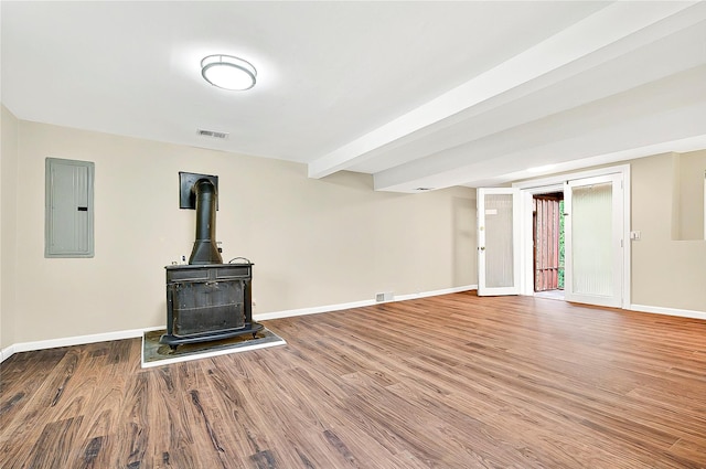 22 Chauncey St, Tuckahoe, NY 10707 - unfurnished living room with electric panel, baseboards, wood finished floors, and a wood stove