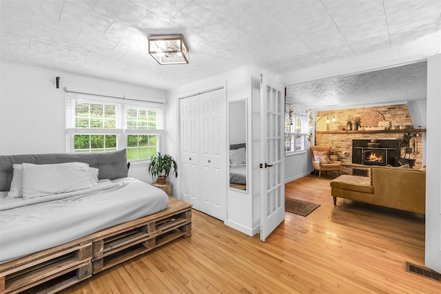 46 Quaker Hill Rd, Monroe, NY 10950 - bedroom featuring a closet, light wood-style floors, visible vents, and a brick fireplace