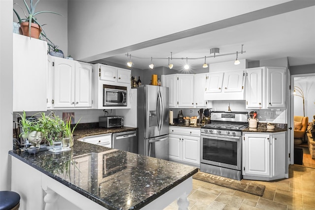 46 Quaker Hill Rd, Monroe, NY 10950 - kitchen featuring a peninsula, stainless steel appliances, white cabinets, and dark stone countertops