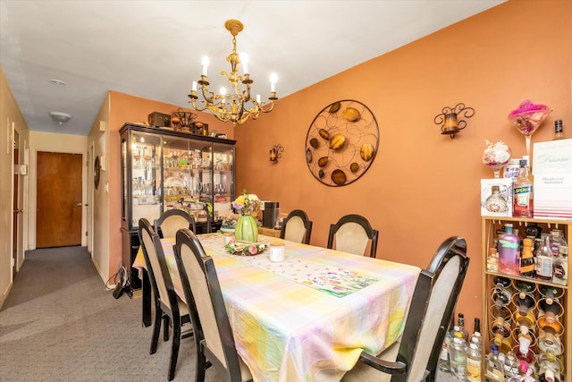 carpeted dining space with a chandelier