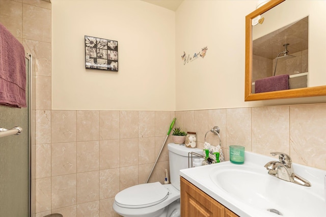 full bathroom with a shower with shower door, vanity, toilet, and tile walls