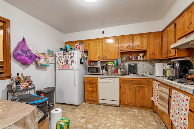 kitchen featuring brown cabinetry, white appliances, light countertops, and under cabinet range hood
