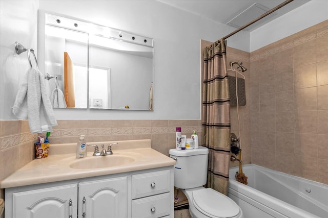 bathroom featuring toilet, tile walls, a wainscoted wall, vanity, and shower / tub combo
