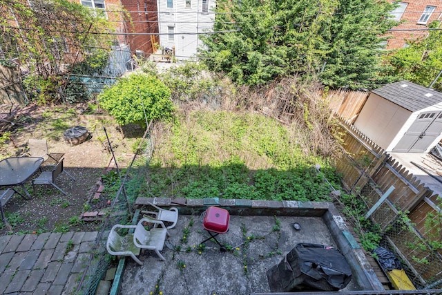 view of yard with a storage shed, an outdoor structure, and a fenced backyard