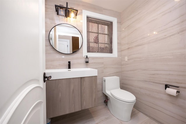 half bath featuring toilet, tile walls, and vanity