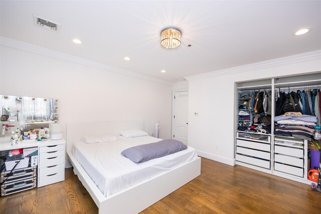 bedroom with crown molding, wood finished floors, recessed lighting, a closet, and baseboards