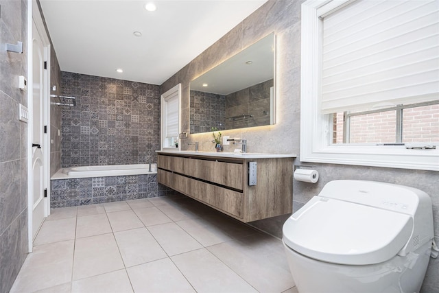 bathroom featuring tile patterned floors, a relaxing tiled tub, tile walls, toilet, and vanity