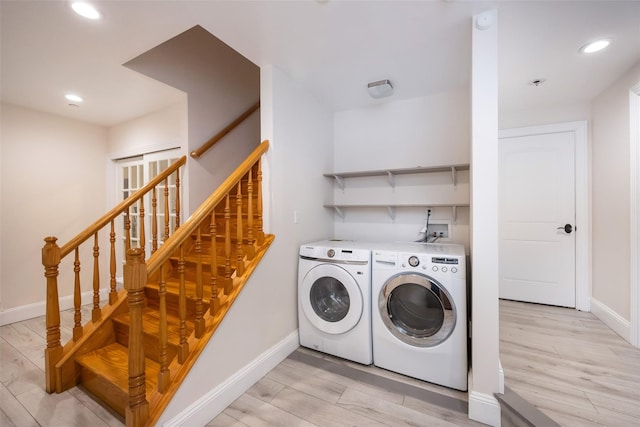 clothes washing area with washer and clothes dryer, light wood finished floors, baseboards, and recessed lighting