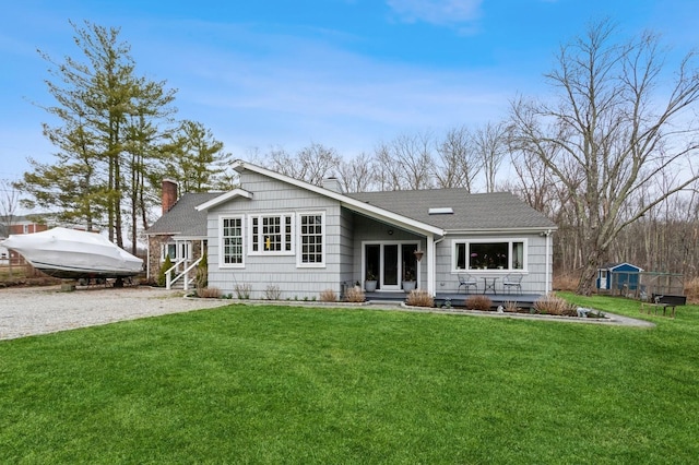 back of house featuring a yard, a chimney, and entry steps
