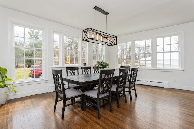 dining area with a baseboard radiator, a notable chandelier, baseboards, and dark wood finished floors