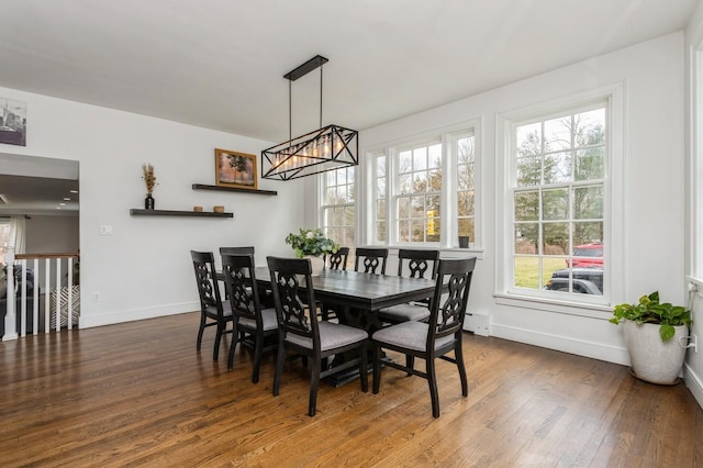 dining room with baseboards, a wealth of natural light, a notable chandelier, and wood finished floors