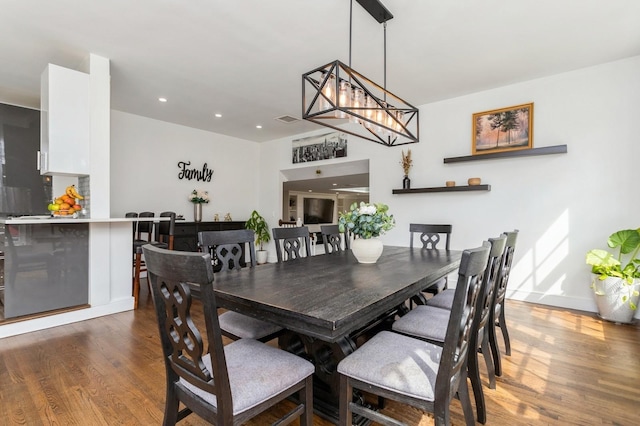 dining room featuring a chandelier, recessed lighting, and wood finished floors