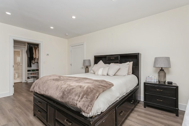 bedroom with light wood-type flooring, baseboards, and recessed lighting