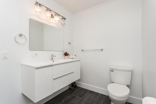 bathroom featuring wood tiled floor, toilet, baseboards, and vanity