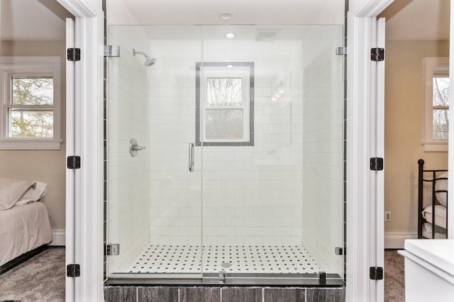 ensuite bathroom with a stall shower, connected bathroom, and a healthy amount of sunlight
