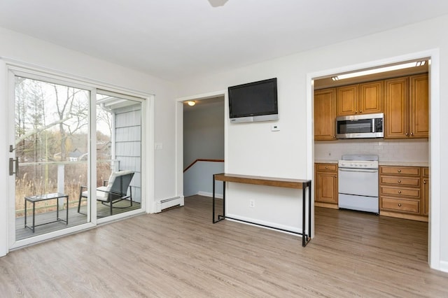 interior space with stainless steel microwave, light wood-style flooring, white electric stove, and brown cabinets