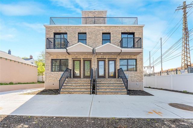 3824 56th St, Woodside, NY 11377 - view of front of property featuring covered porch, brick siding, fence, and a balcony