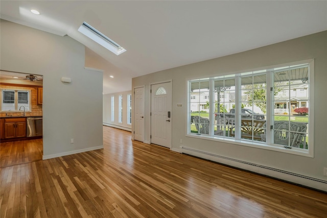 311 Atlantic, Massapequa Park, NY 11762 - foyer featuring a baseboard heating unit, wood finished floors, vaulted ceiling, a skylight, and baseboards