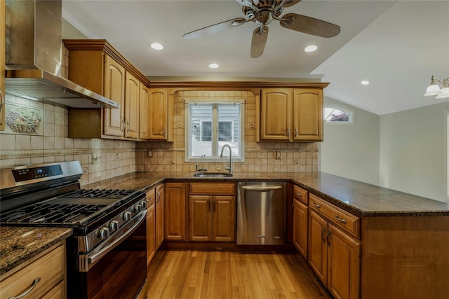 311 Atlantic, Massapequa Park, NY 11762 - kitchen featuring appliances with stainless steel finishes, wall chimney range hood, a sink, a peninsula, and light wood-type flooring