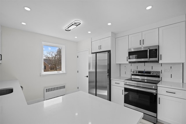 247 Osborne Hill Rd, Fishkill, NY 12524 - kitchen with recessed lighting, radiator, light countertops, white cabinets, and appliances with stainless steel finishes