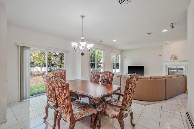 dining room with a chandelier, light tile patterned flooring, recessed lighting, a glass covered fireplace, and baseboard heating