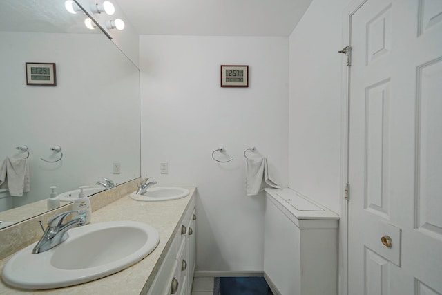 full bath featuring double vanity, baseboards, and tile patterned flooring