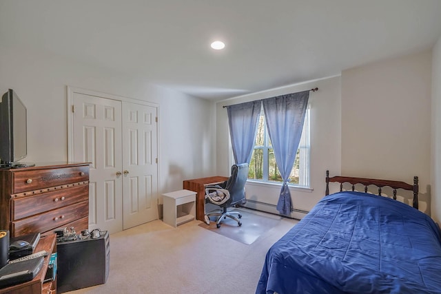 carpeted bedroom featuring baseboard heating and a closet