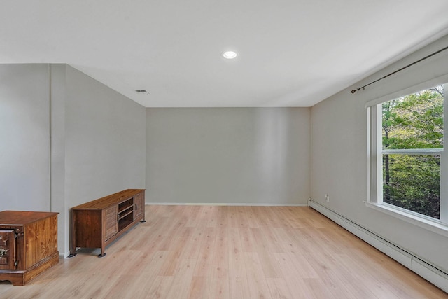 spare room featuring baseboard heating, wood finished floors, recessed lighting, and baseboards