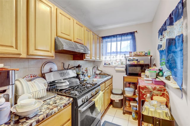 1934 Chatterton Ave, Bronx, NY 10472 - kitchen with stainless steel range with gas stovetop, under cabinet range hood, black microwave, a sink, and light tile patterned flooring