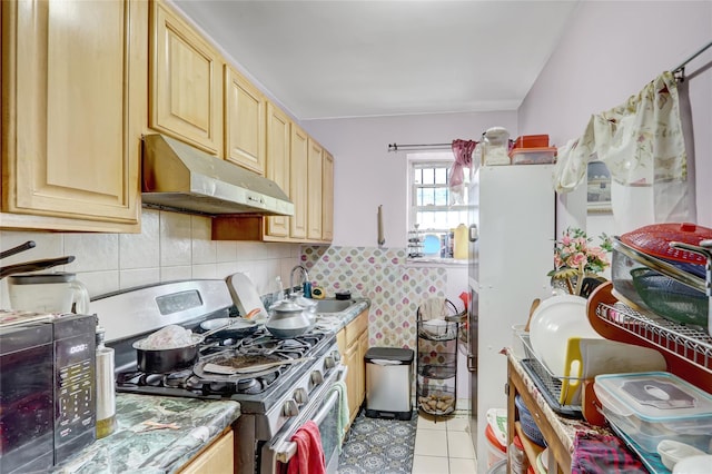 1934 Chatterton Ave, Bronx, NY 10472 - kitchen with stainless steel gas range, under cabinet range hood, a sink, light brown cabinets, and light tile patterned flooring