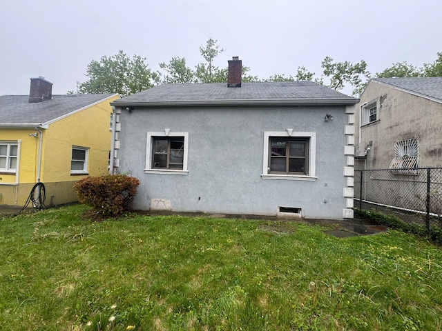 548 S 10th Ave, Mount Vernon, NY 10550 - back of property with fence, stucco siding, a chimney, and a lawn