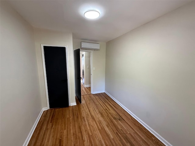 3106 Eastchester Rd, Bronx, NY 10469 - unfurnished bedroom with a wall mounted air conditioner, wood finished floors, and baseboards