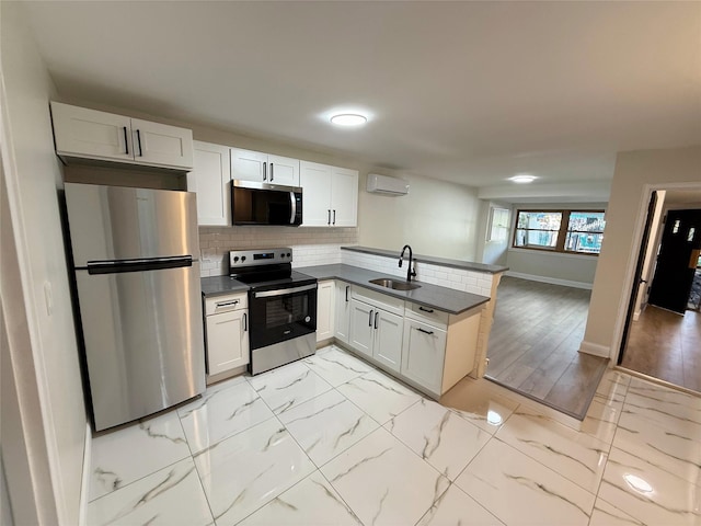 3106 Eastchester Rd, Bronx, NY 10469 - kitchen featuring a sink, a peninsula, a wall mounted air conditioner, baseboards, and appliances with stainless steel finishes