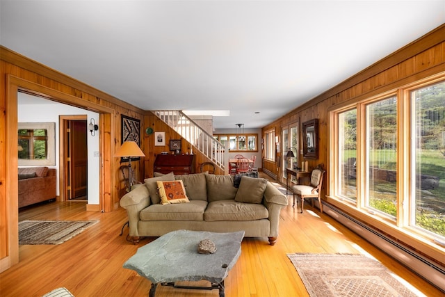 11 Louie Way, Woodstock, NY 12498 - living room featuring baseboard heating, wood walls, plenty of natural light, stairs, and light wood-style flooring