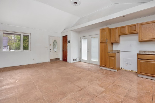 kitchen featuring lofted ceiling, french doors, and light tile patterned floors
