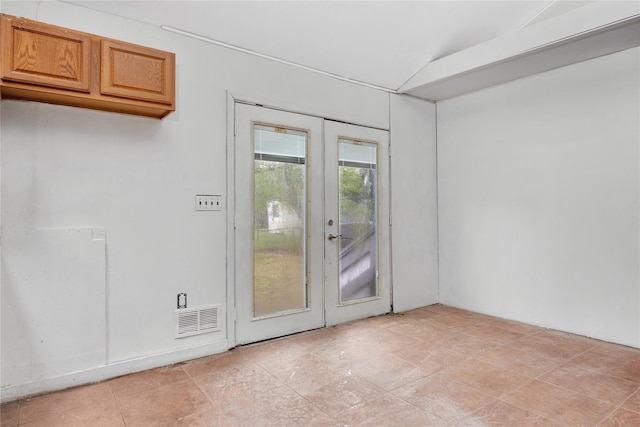 doorway to outside featuring lofted ceiling and french doors