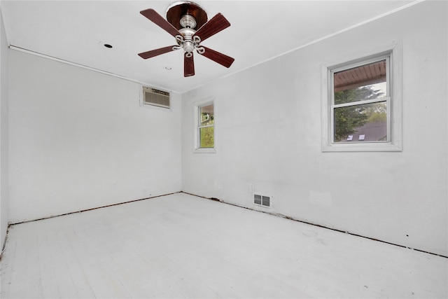 empty room with a wall unit AC and ceiling fan