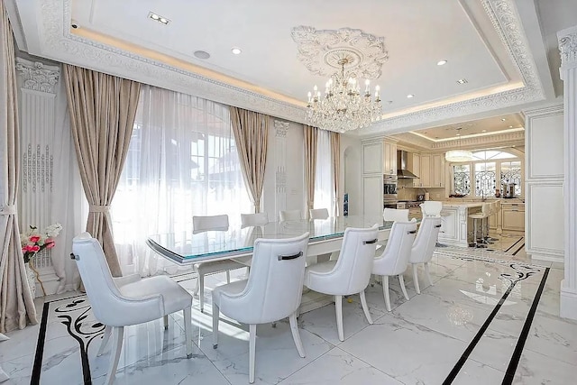dining area featuring marble finish floor, recessed lighting, crown molding, a raised ceiling, and a notable chandelier