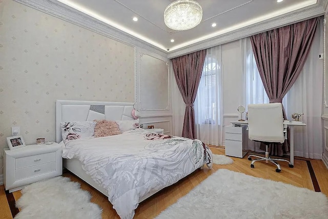 bedroom with recessed lighting, wallpapered walls, a chandelier, a wainscoted wall, and light wood-style floors