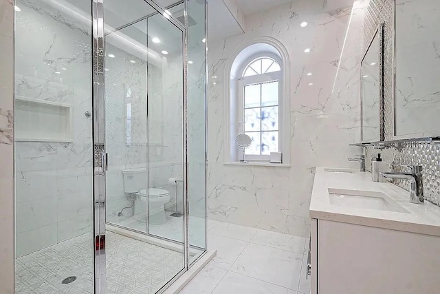 full bathroom featuring a sink, double vanity, toilet, and a marble finish shower