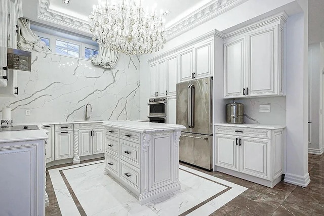 kitchen featuring an inviting chandelier, stainless steel appliances, light countertops, decorative backsplash, and marble finish floor