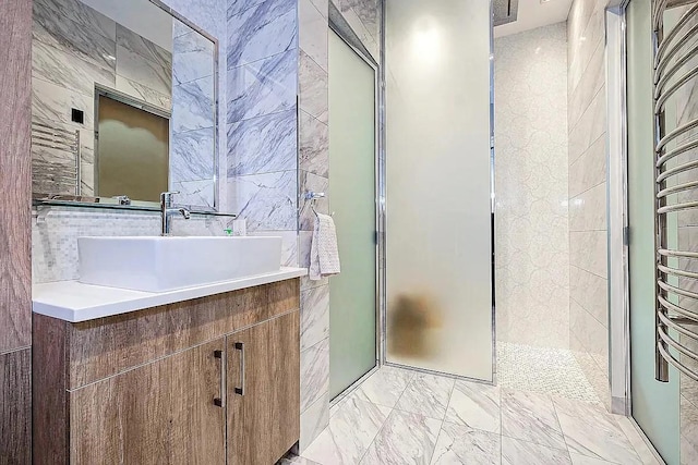 full bath with vanity, tile walls, a shower stall, and marble finish floor