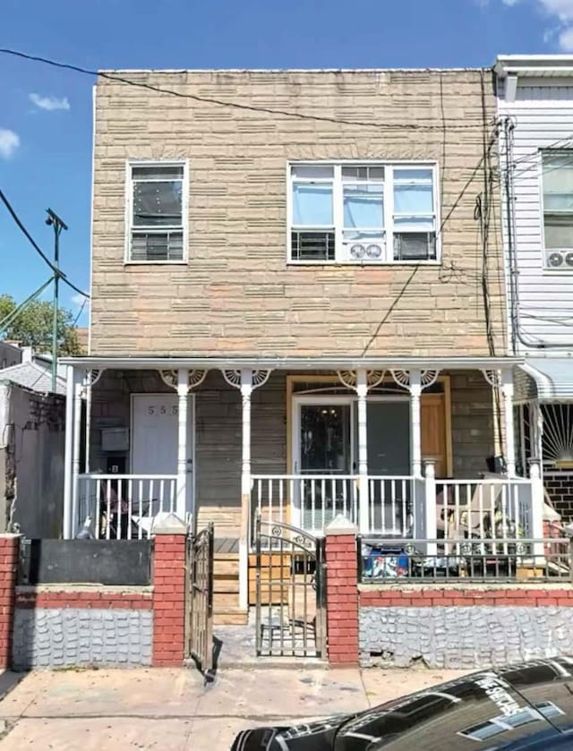 multi unit property featuring a porch and stone siding