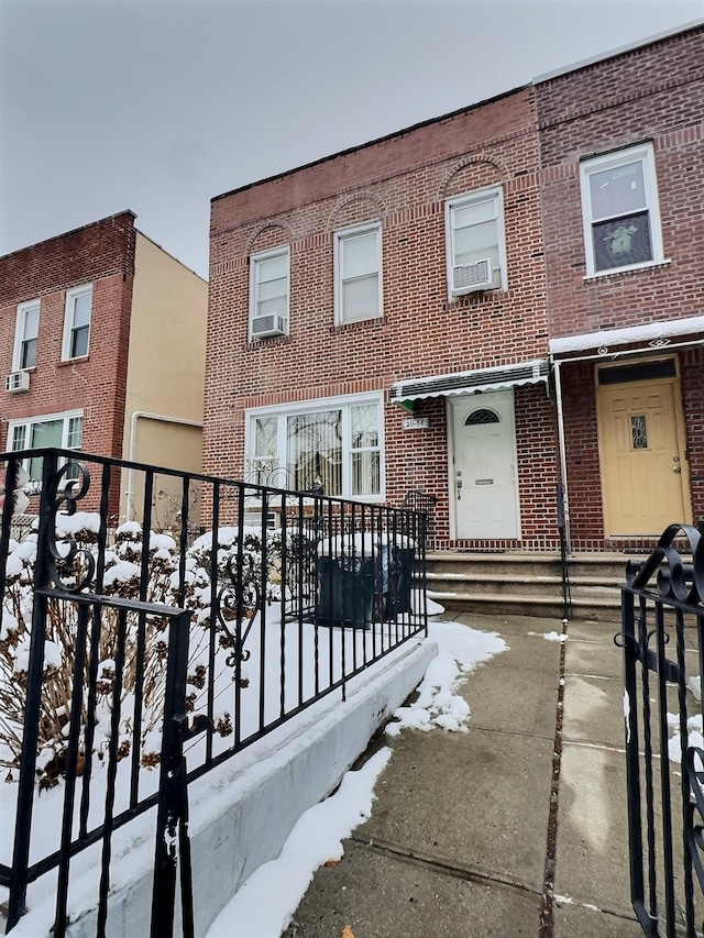multi unit property featuring cooling unit, brick siding, and a balcony