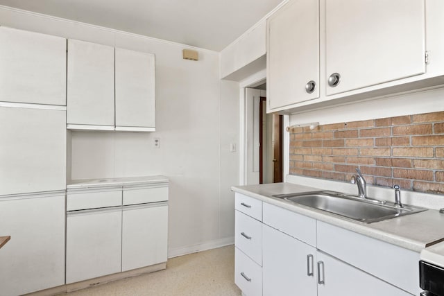 20-58 35th St, Astoria, NY 11105 - kitchen featuring a sink, light countertops, baseboards, and white cabinets